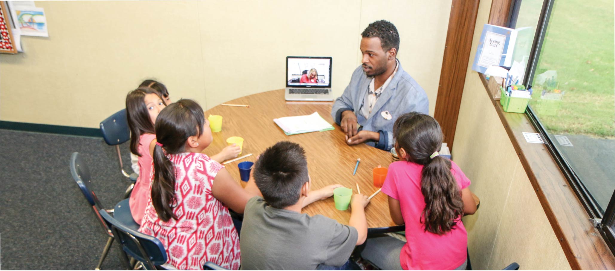 image of kids and teacher at table